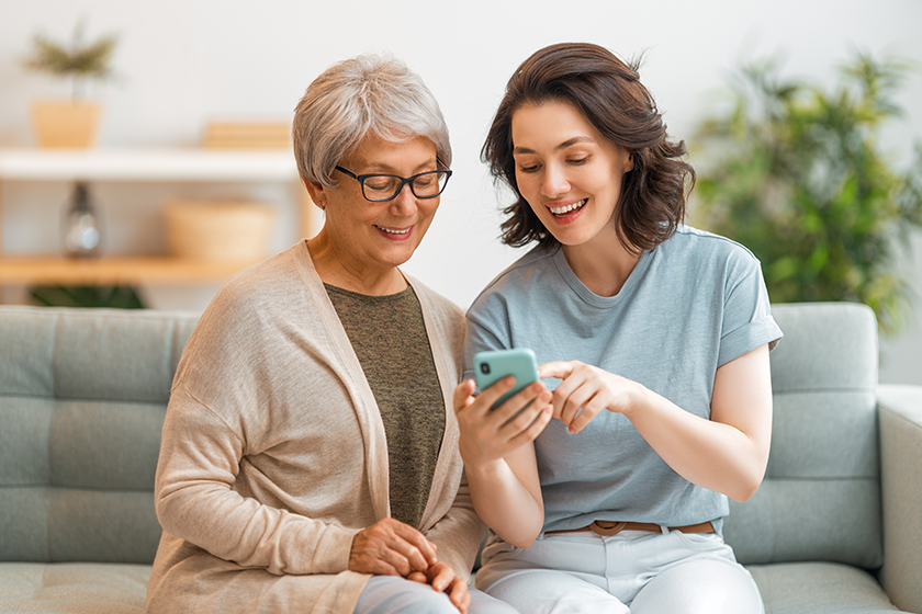 Senior woman and daughter using smartphone